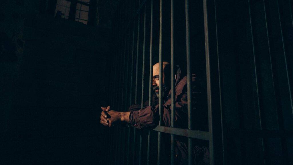 A Prisoner Standing behind the Bars