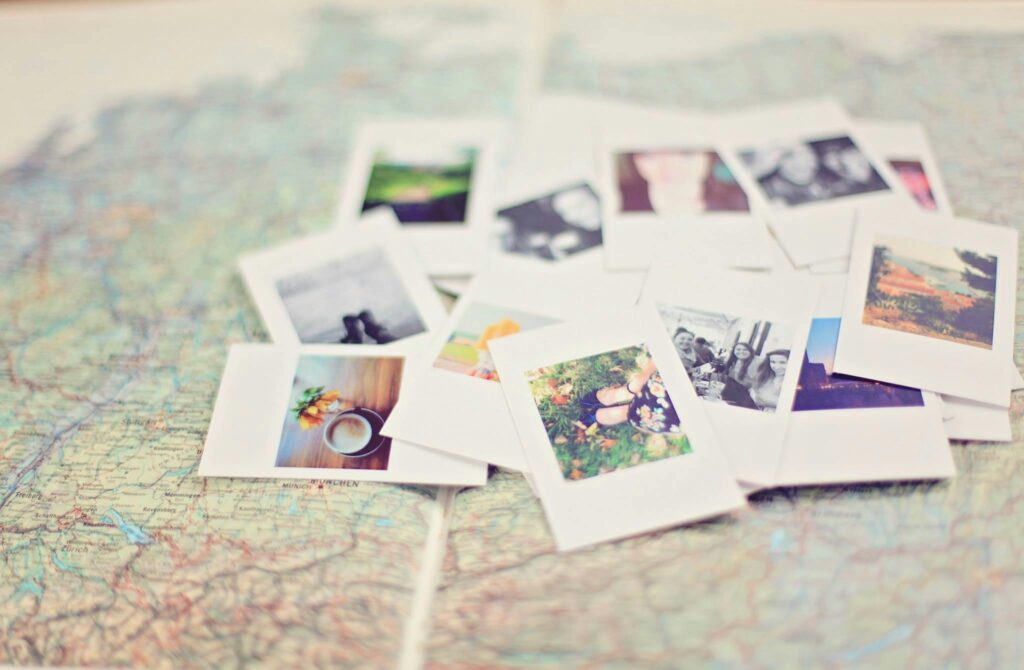 A collection of Polaroid memories spread across a map, symbolizing travel adventures.